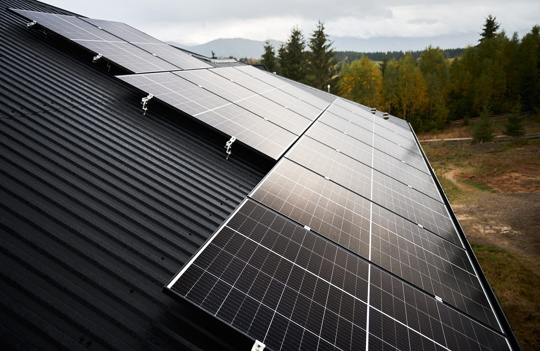 Solar photovoltaic batteries on a roof. Installation of solar panels on a top of house in forest. Concept of alternative energy sources in modern life.